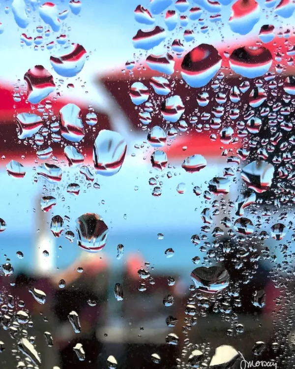 Photographie impressionniste en tirage limité, parasols rouges flous sur fond de ciel et mer bleue - Sophie Moisan
