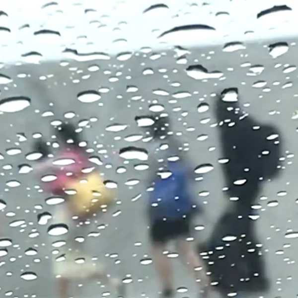 Photographie impressionniste Bubble team de Sophie Moisan, trois silhouettes colorées et floues qui marchent sous la pluie.