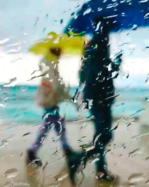 Photographie d’art impressionniste en tirage limité, un couple sous des parapluies jaune et bleu marchand sous la pluie au bor de la mer - Sophie Moisan
