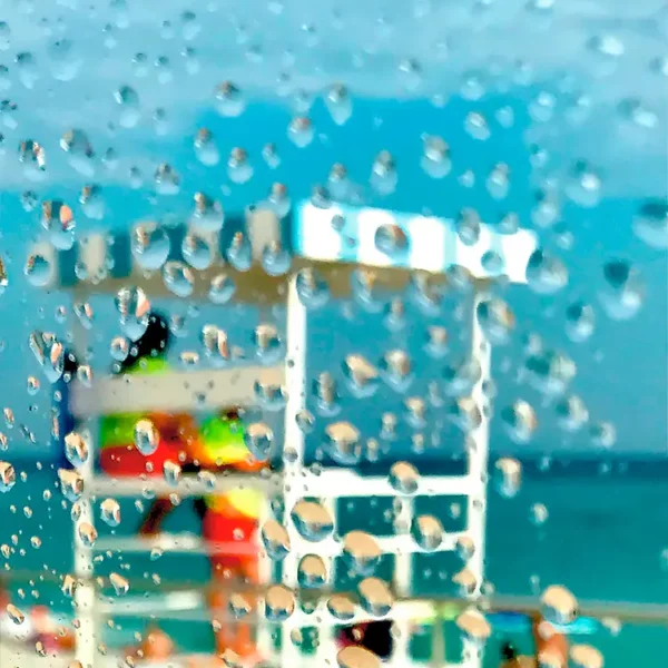 Photographie impressionniste La cage aux oiseaux de Sophie Moisan, silhouette floue d'un poste de vigie en bois blanc sous le ciel bleu et la mer verte de la Riviera française.