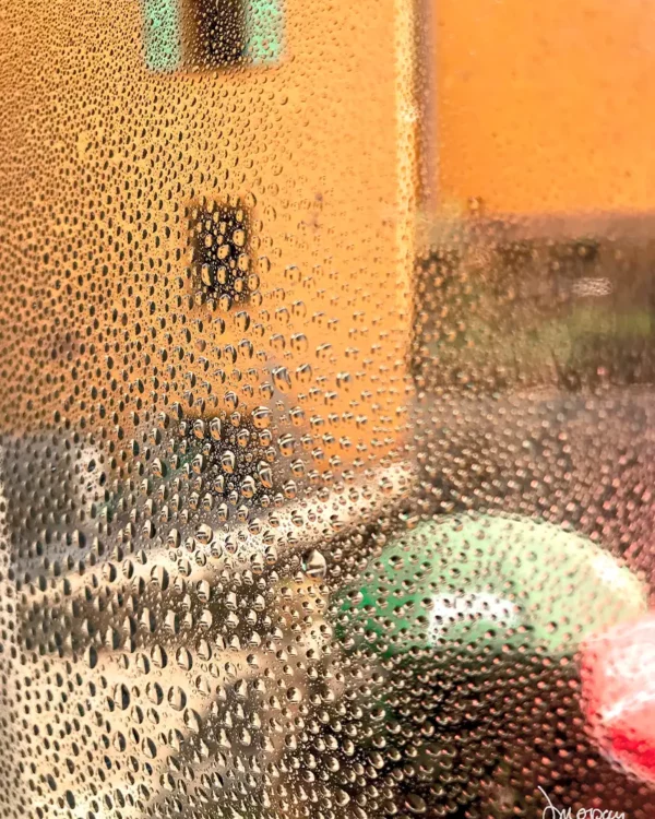 Photographie impressionniste en tirage limité, façade floue orangée et parasols colorés dans le sud de la France. Deuxième prix catégorie photographies de L'abstract Art 2025 — Sophie Moisan