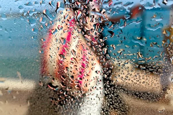 Photographie impressionniste L'africaine de Sophie Moisan, jeune femme tout en couleurs se promenant sur fond de ciel et mer bleue.