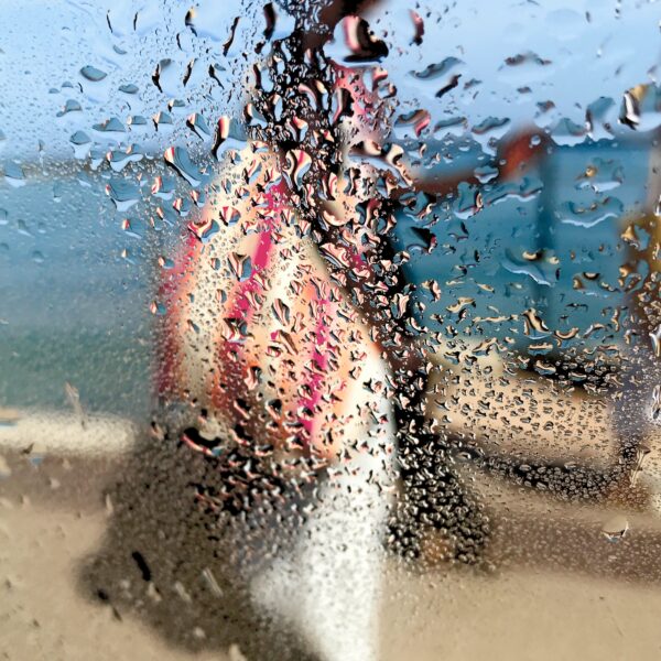 Photographie impressionniste L'africaine de Sophie Moisan, jeune femme tout en couleurs se promenant sur fond de ciel et mer bleue.