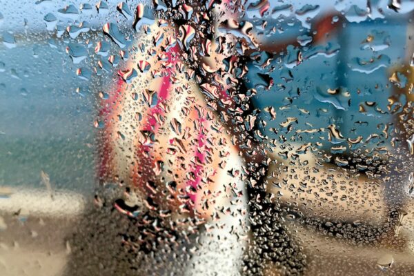 Photographie d’art impressionniste en tirage limité, silhouette féminine sous la pluie, mer et ciel bleu - Sophie Moisan