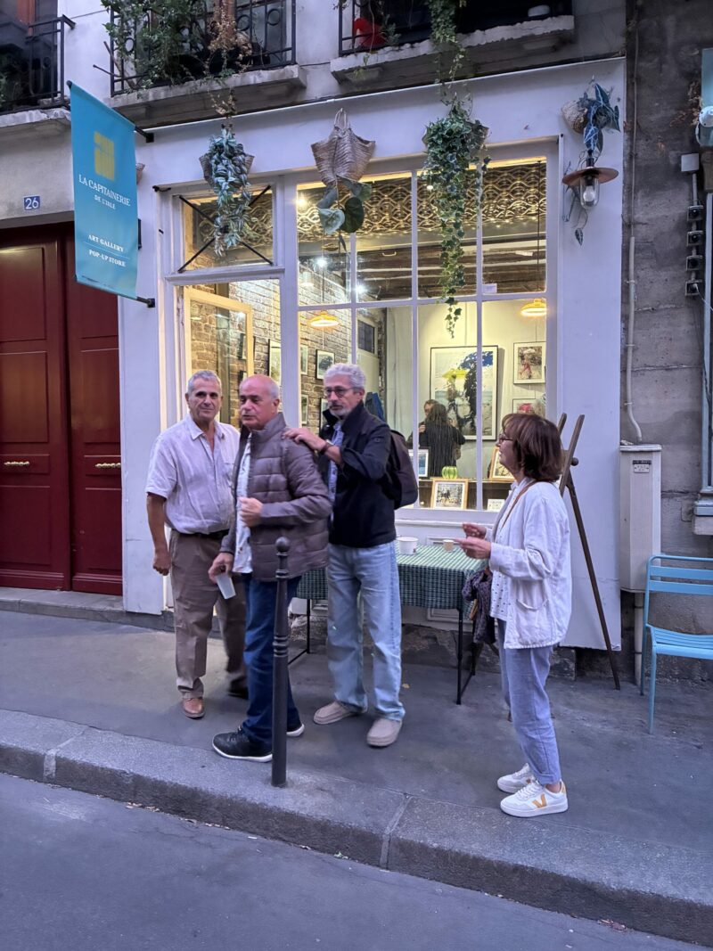 Visiteurs devant la vitrine éclairée de la galerie La Capitainerie de l'Ile de a cité à Paris, où sont exposées les photographies de Sophie Moisan